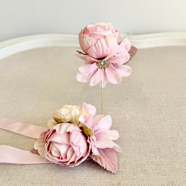 Pink floral corsage on a beige cushion with a light gray background