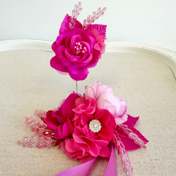 Pink floral corsage with ribbons on a beige surface