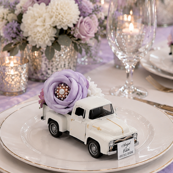 Decorative table setting with miniature trucks and floral arrangements on a white tablecloth.