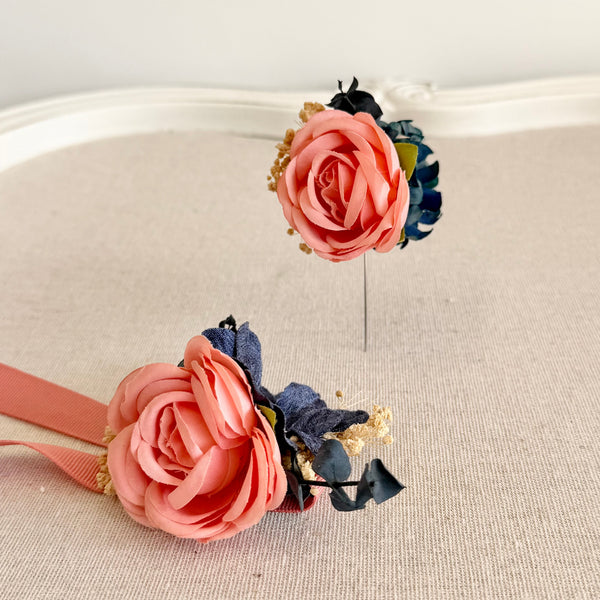 Pair of pink and blue floral earrings on a beige surface.