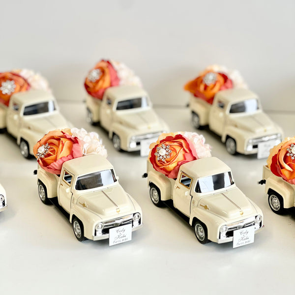 Small model cars with floral arrangements on a white background