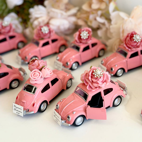 Pink toy cars with decorative flowers on a white surface with floral background