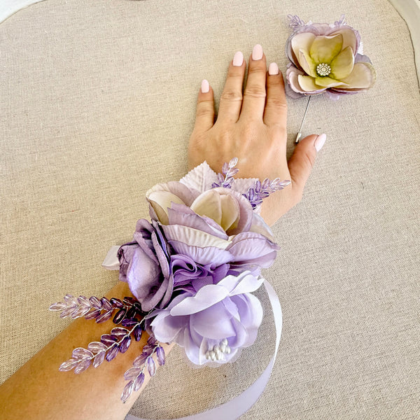 Hand with a wrist corsage on a beige surface