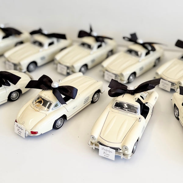 Collection of white model cars with black ribbons on a white background