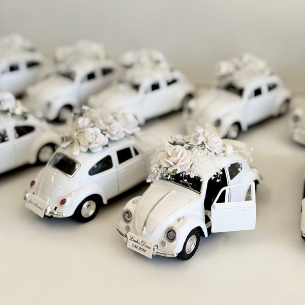 Collection of white model cars with decorative elements on a light background