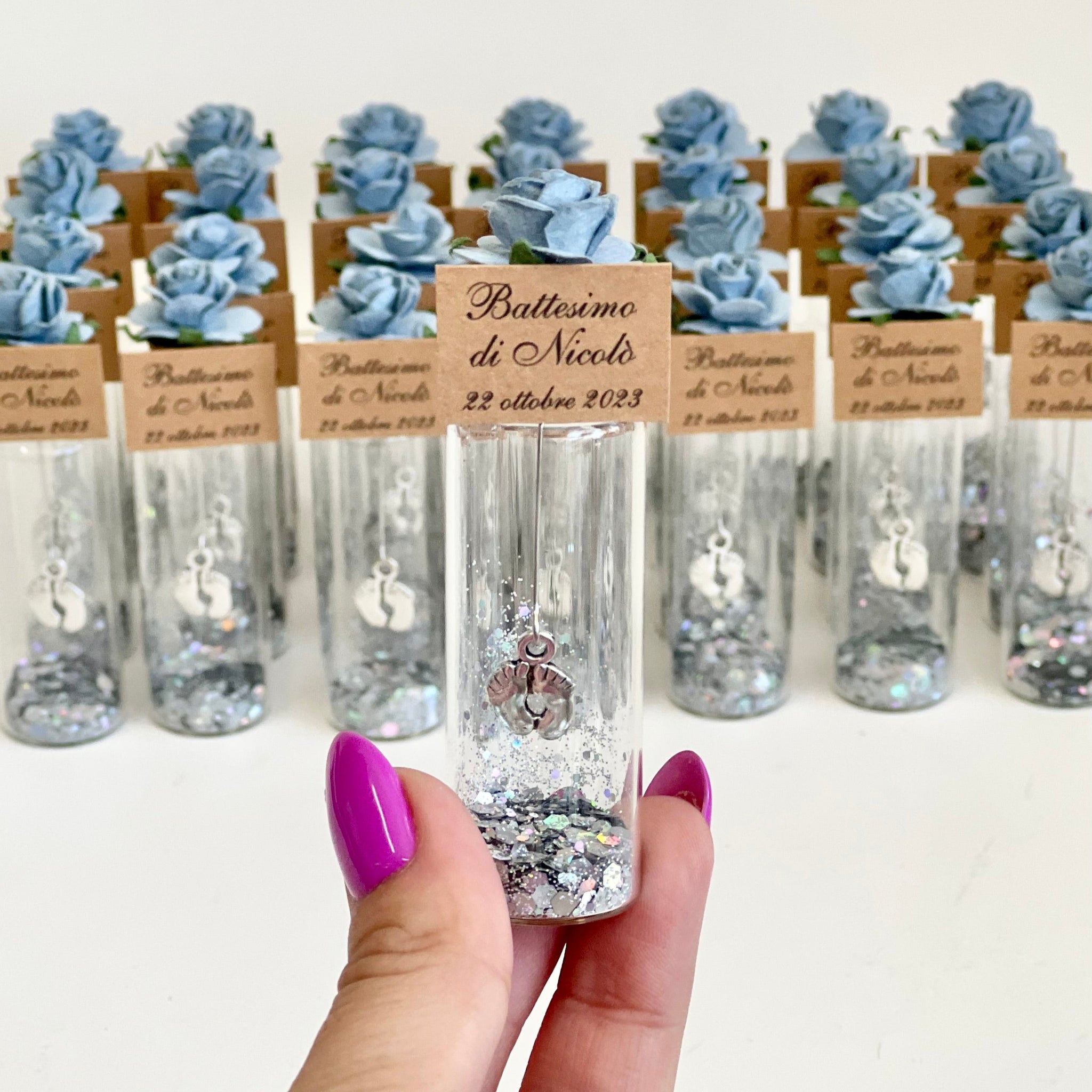 Decorative bottles with small figurines and personalized labels on a white background