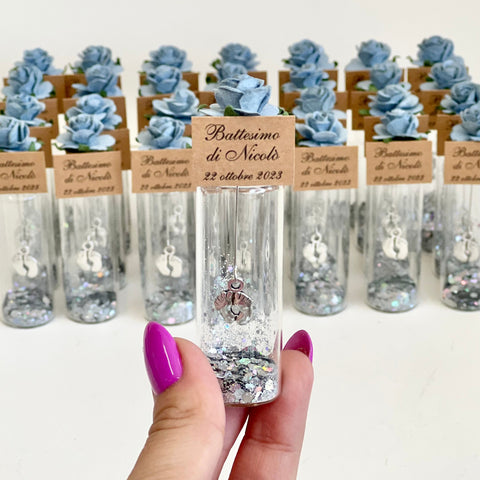 Decorative bottles with small figurines and personalized labels on a white background