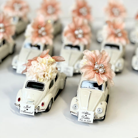 Decorative car models with floral arrangements on a white background