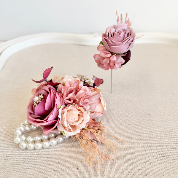 Two floral hair accessories with pink and white flowers on a beige surface.