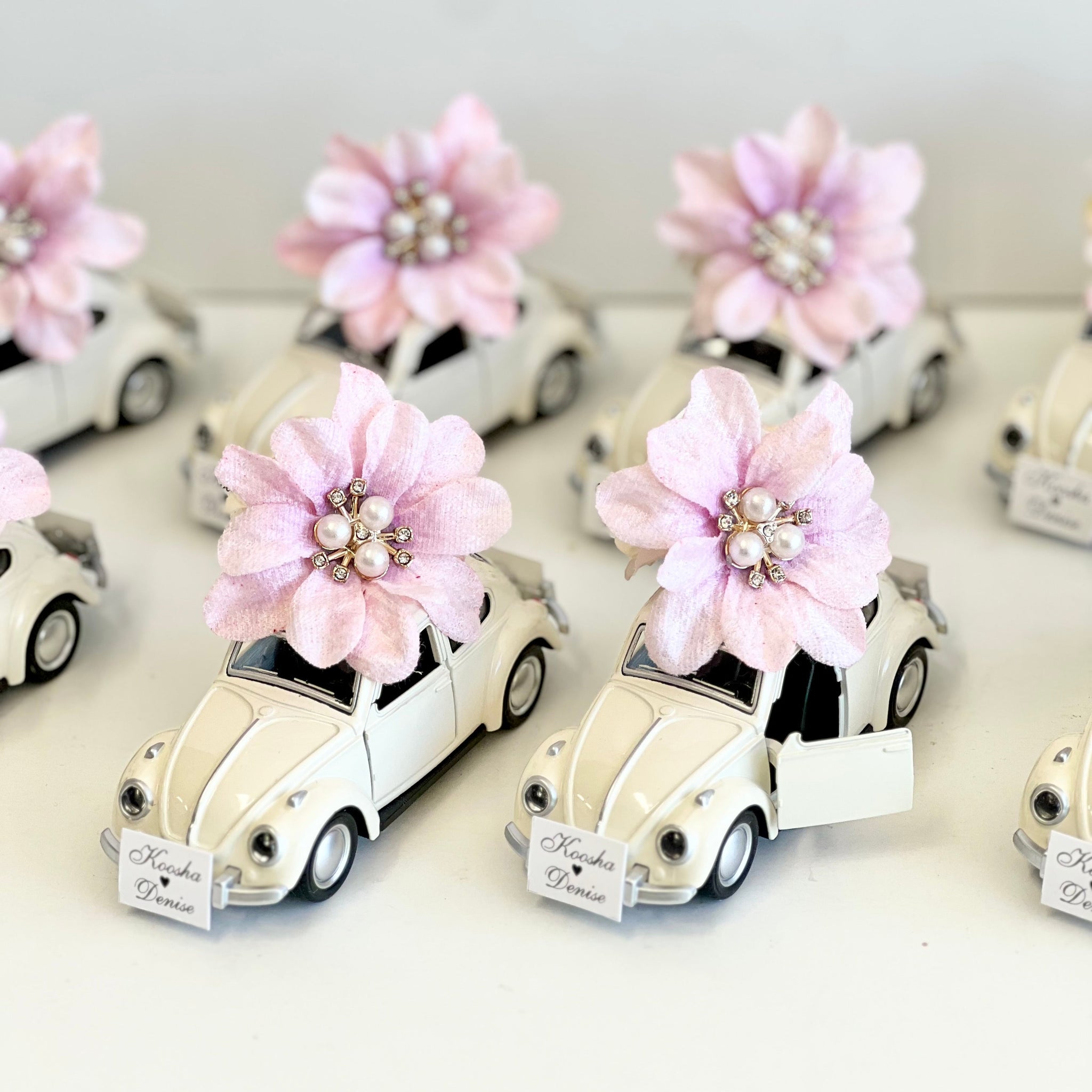 Small white cars with pink flowers on a white background