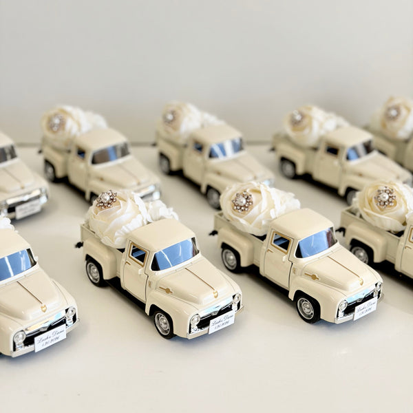 Collection of miniature white cars with decorative elements on a light gray background