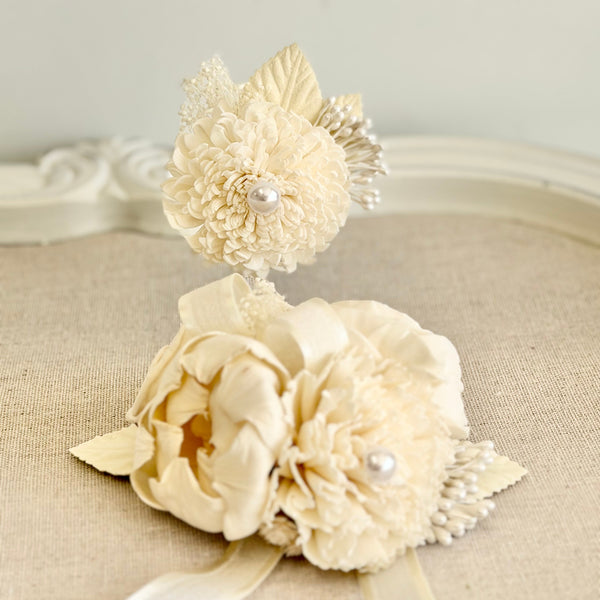 Cream-colored floral hair accessory with pearls on a beige surface