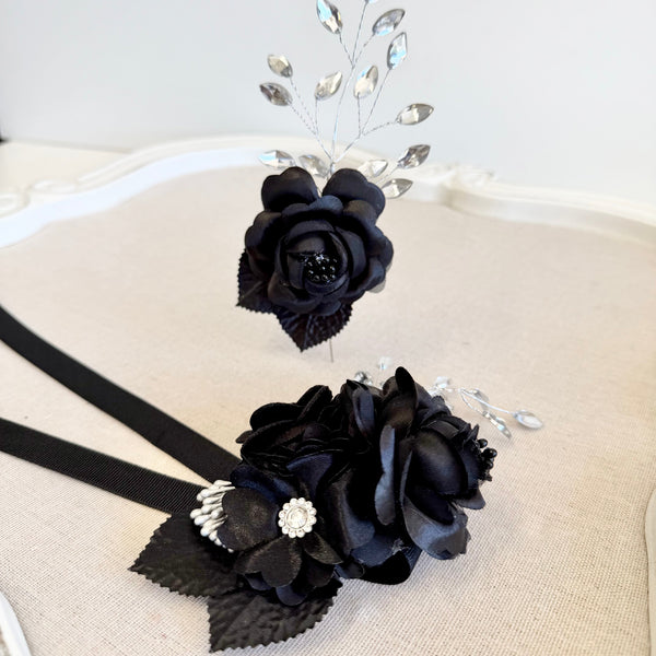 Black floral hair accessory with rhinestones on a white background