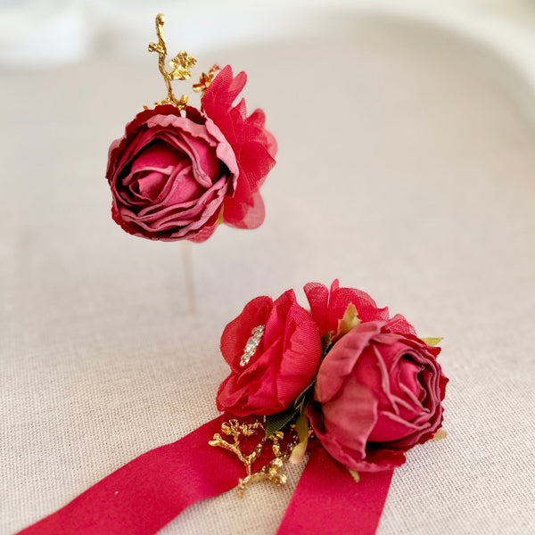 Red floral corsage with a red ribbon on a beige background