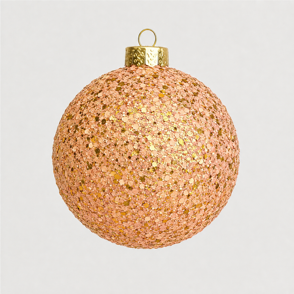 A spherical Christmas ornament covered in dense rose gold and gold glitter, featuring a textured gold cap and a hanging loop at the top, set against a plain light gray background.