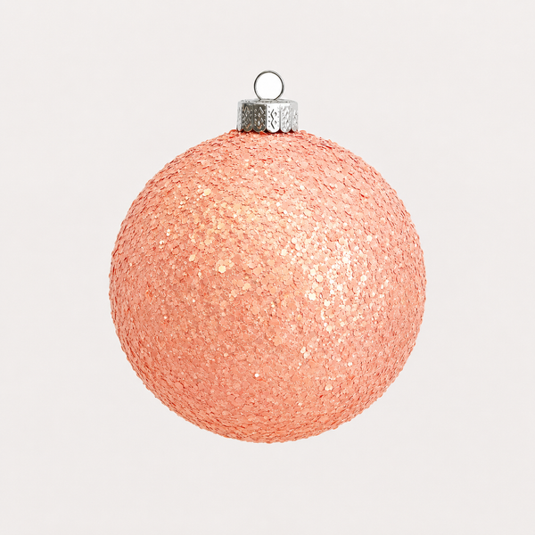 A spherical Christmas ornament covered in shimmering rose gold glitter, featuring a silver metallic cap and hanging loop, set against a solid off-white background.
