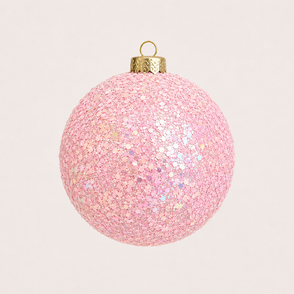 A spherical pink sequin Christmas ornament with a gold hanging loop and cap, shown against a plain light beige background.