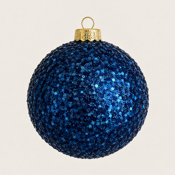 A round blue glitter Christmas ornament with a gold metal cap and hanging loop, shown against a plain light beige background.