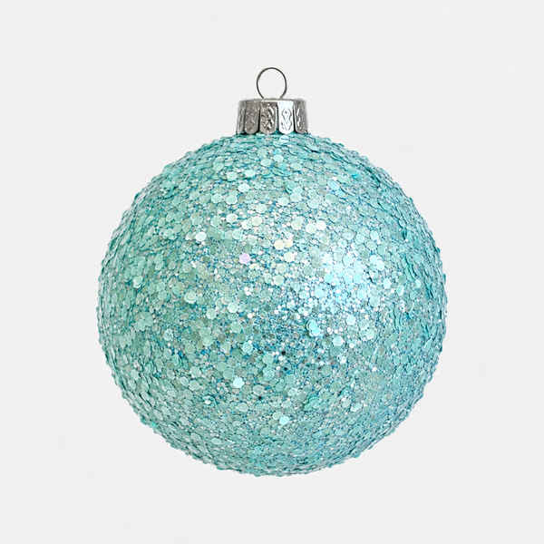 A round, glittery light blue Christmas ornament with a silver metal cap and hanging loop, shown against a plain light gray background.