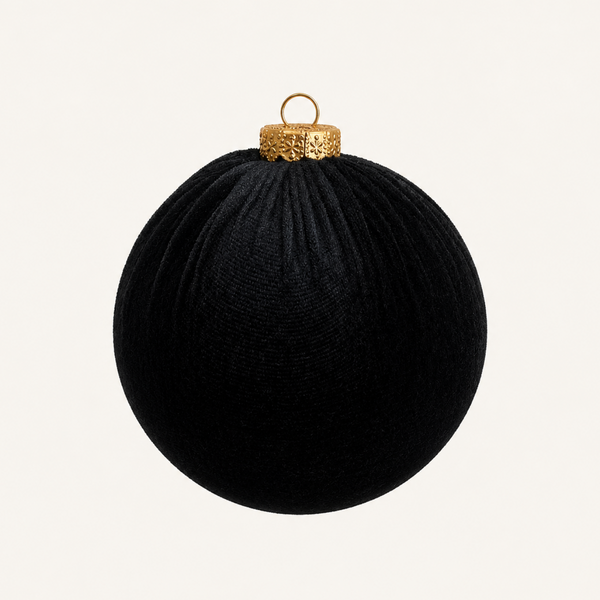 A black textured Christmas ornament ball with a gold cap and hanging loop, centered on a light cream background.