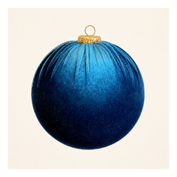 A round blue velvet Christmas ornament with a gold hanging loop and cap, shown against a plain off-white background.