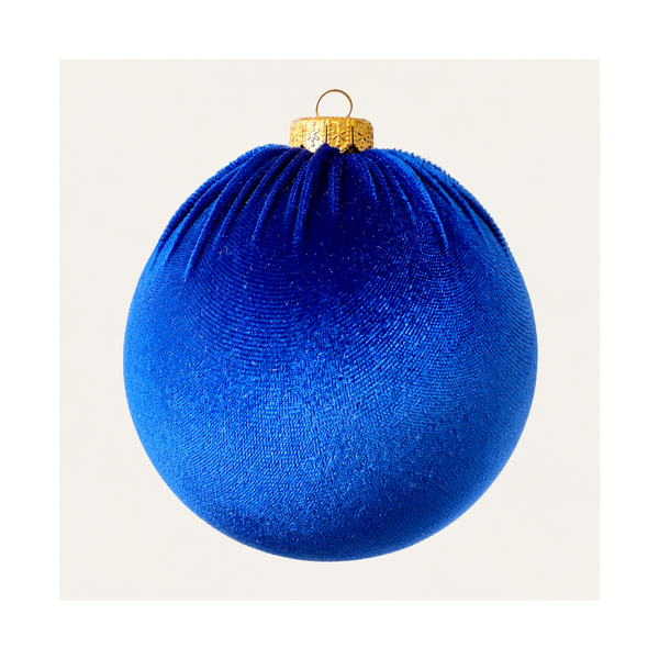A royal blue velvet Christmas ornament ball with a textured surface, featuring a gold cap and hanging loop at the top, shown against a plain off-white background.