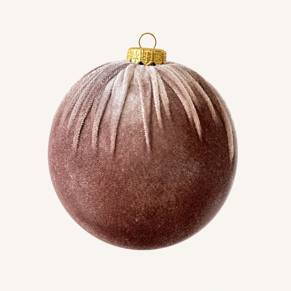 A spherical Christmas ornament made of textured velvet fabric in a dusty rose-brown color, featuring a gold metallic cap and hanging loop at the top, set against a plain off-white background.