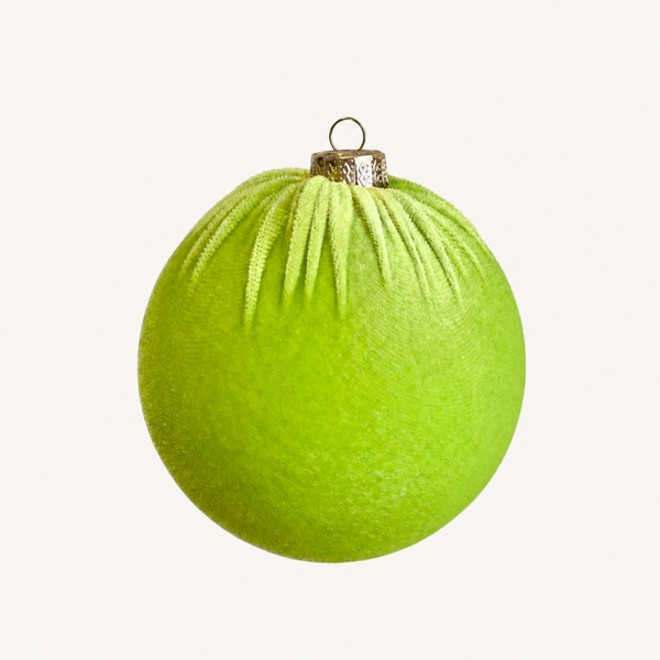 A bright lime green textured Christmas ornament with a gold metal cap and hanging loop, centered on a plain off-white background.