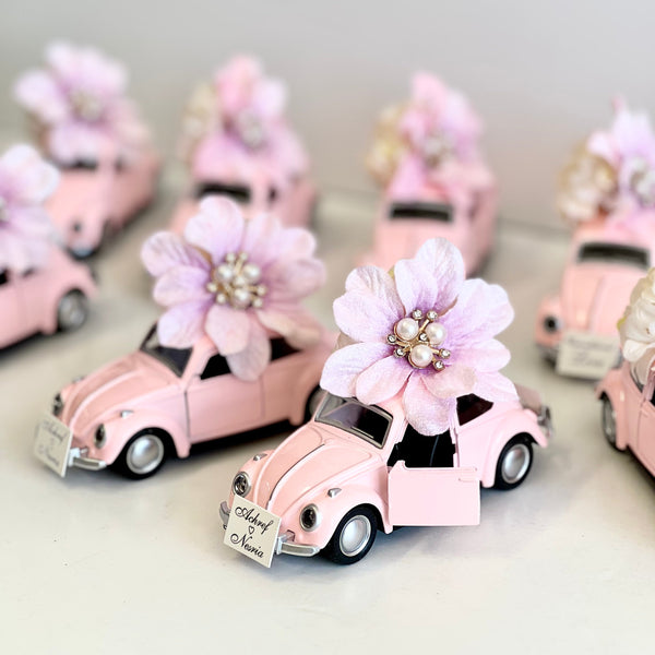 Small pink cars with floral decorations on a light gray background