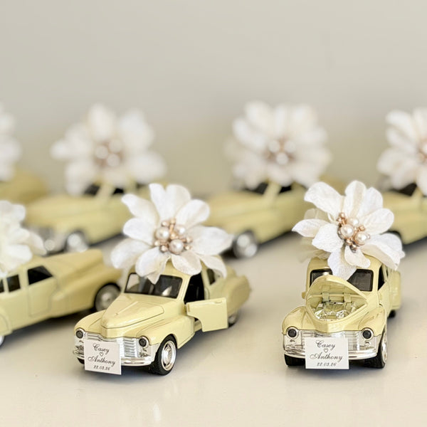 Small model cars decorated with flowers on a light background