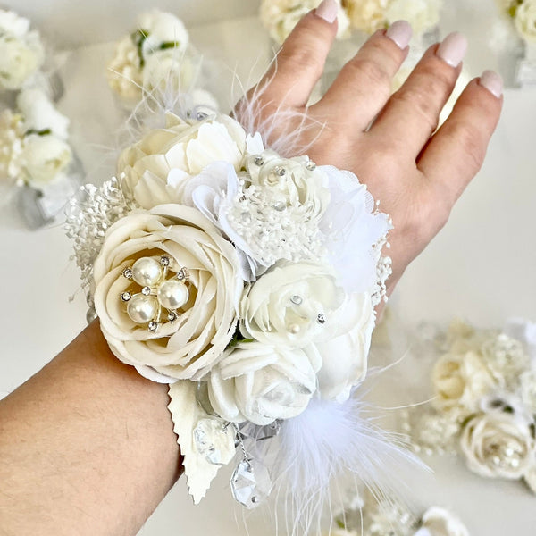White floral wrist corsage with pearls on a white background
