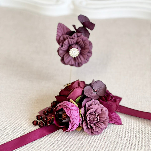 Purple floral corsage and boutonniere on a light background