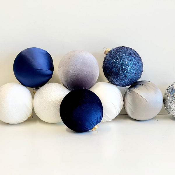 Decorative Christmas balls in blue, silver, and white on a white background