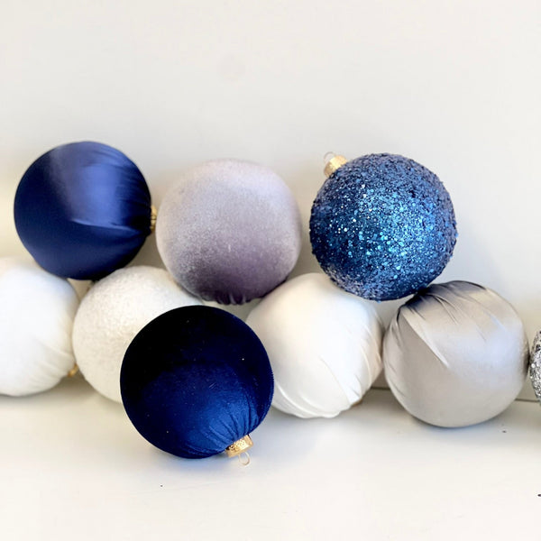Decorative Christmas balls in blue, silver, and white on a white background