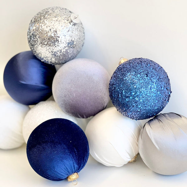 Decorative Christmas balls in blue, silver, and white on a white background