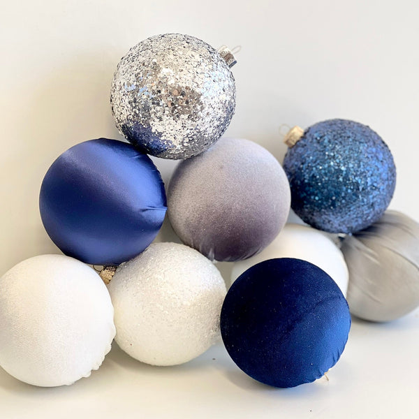 Decorative ornaments in blue, silver, and white on a white background