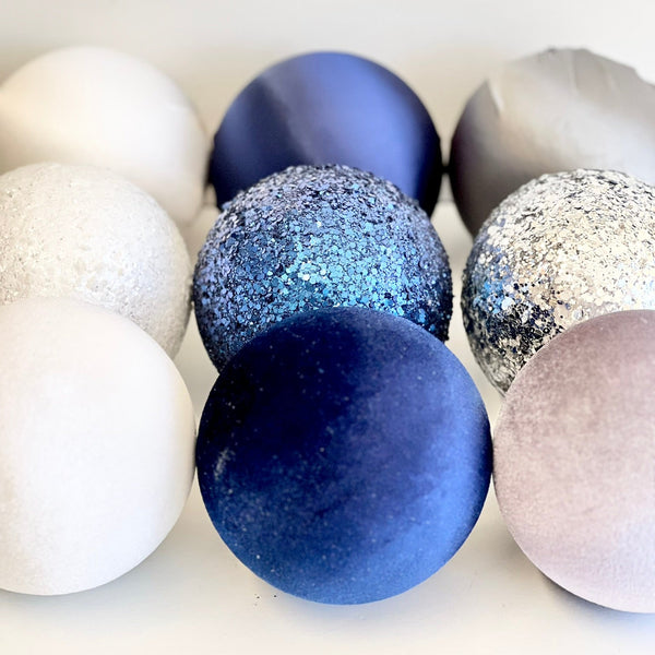 Decorative balls in white, blue, and gray on a light background