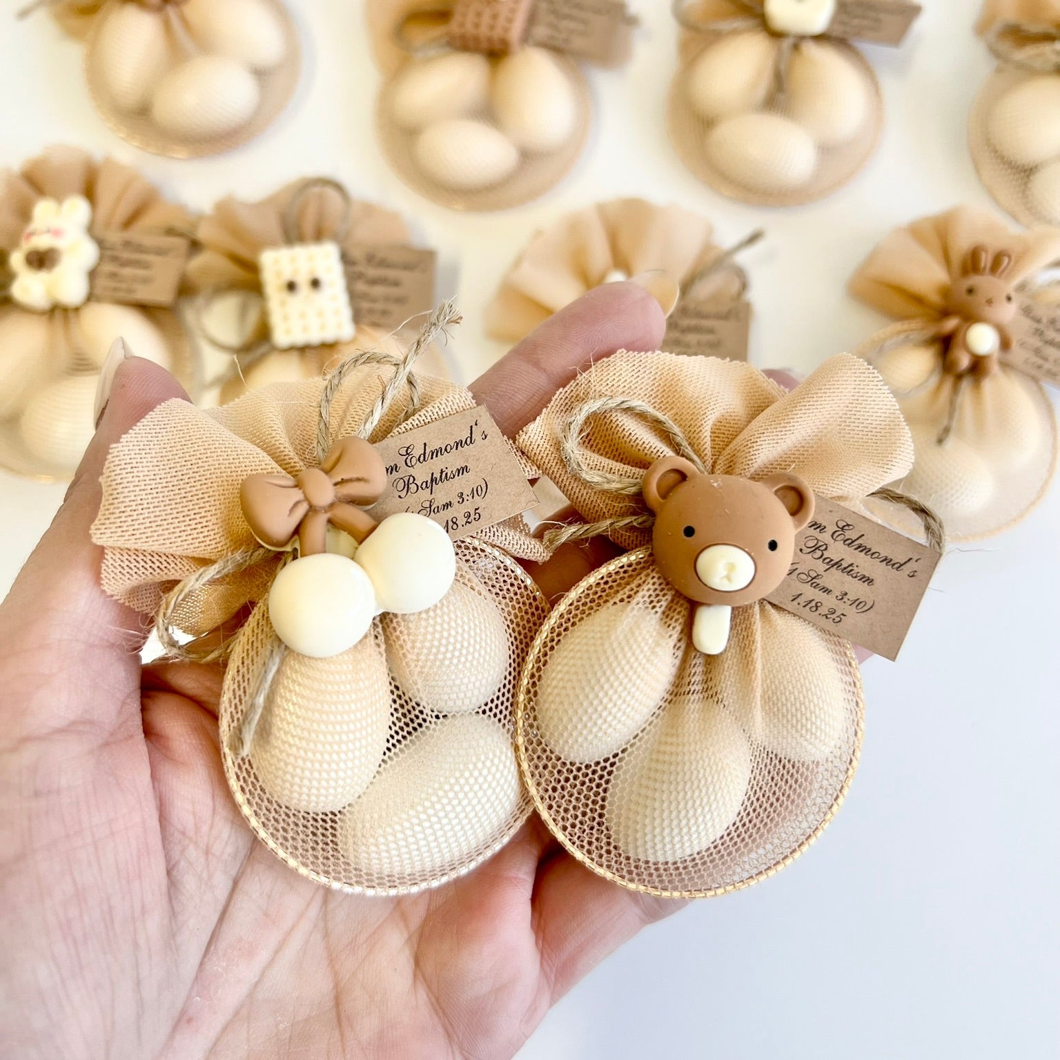 Decorative items with beige ribbons and buttons held by a hand on a white background