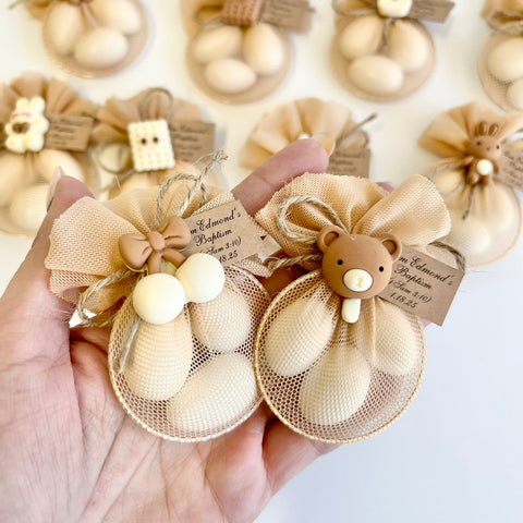 Decorative items with beige ribbons and buttons held by a hand on a white background