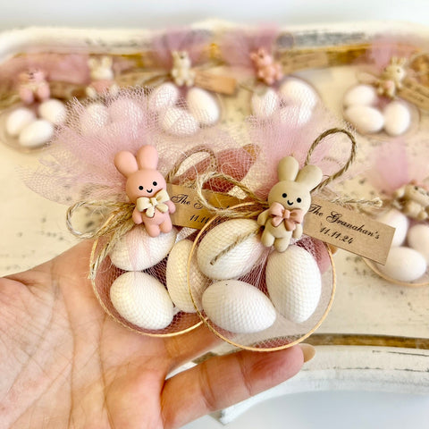 Decorative set with small rabbits and white stones on a textured surface