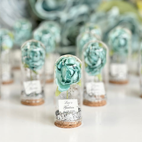 Decorative glass bottles with blue floral arrangements on a white surface.